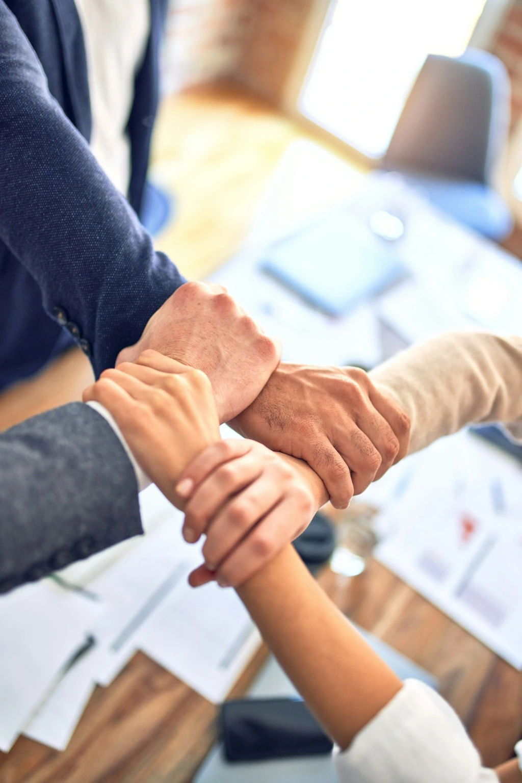 team members gripping wrists in unity gesture